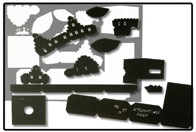 黒い紙から切り取ったお化け屋敷のペーパークラフトのパーツ。窓や文字がくり抜かれている