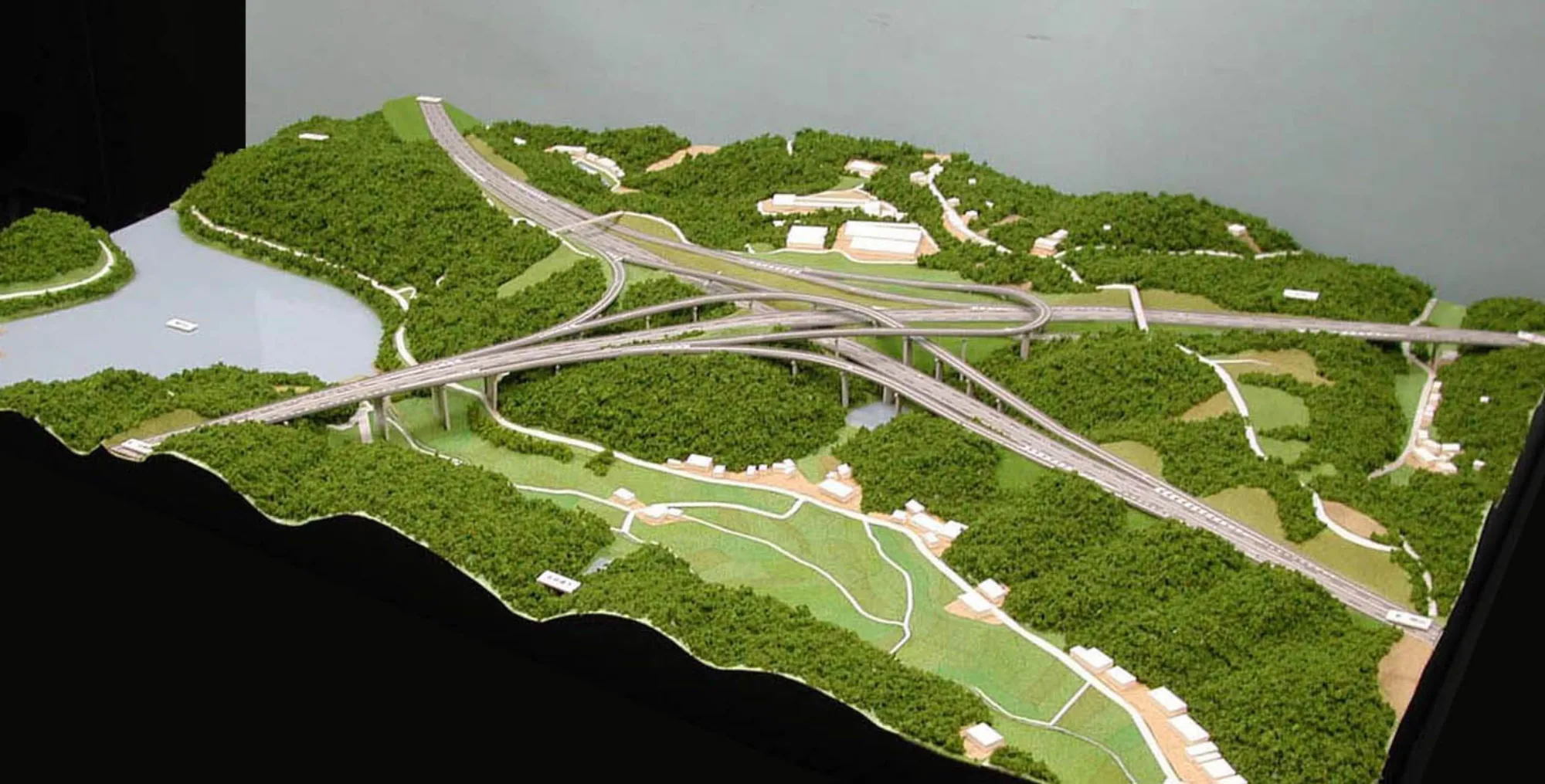 高速道路のジャンクションを再現した地形模型。緑の丘陵と河川、立体交差する道路を構成した情景模型