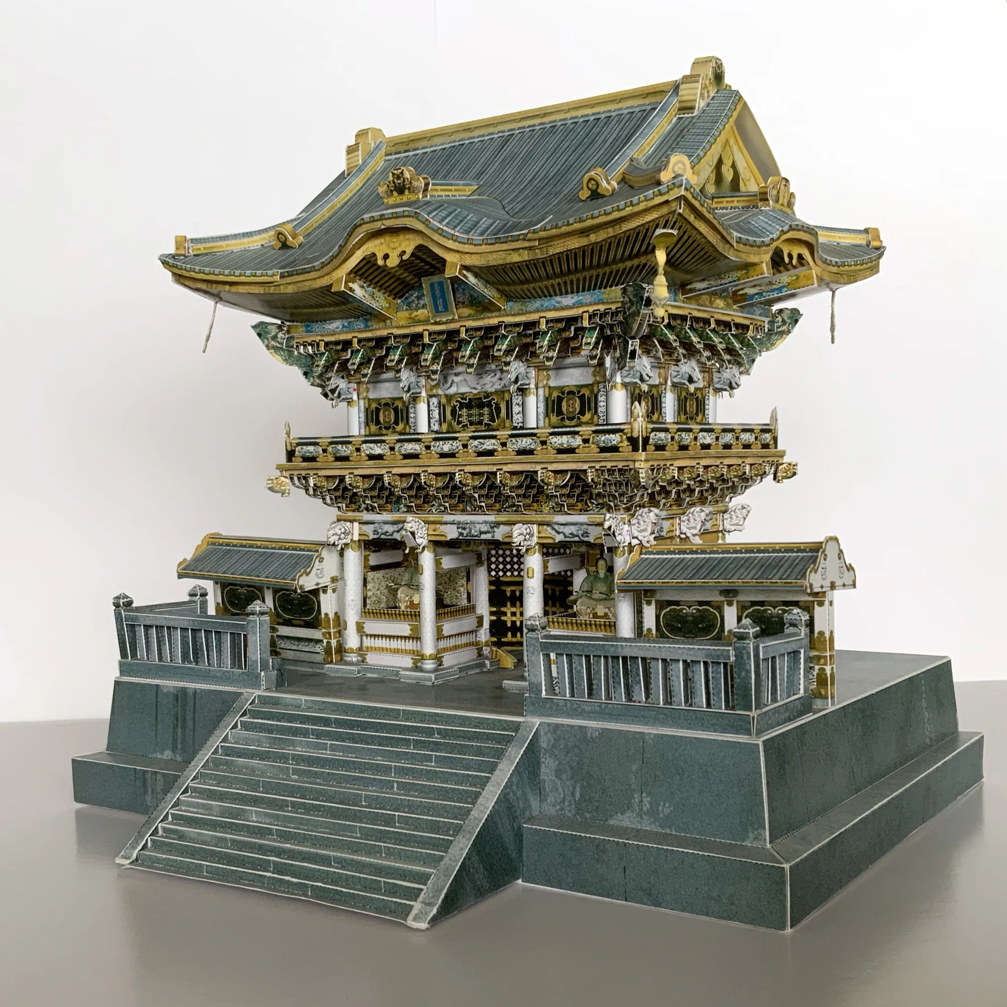 日光東照宮 陽明門のペーパークラフト建築模型を斜めから見た全景。金色の彫刻装飾と組物、石段までを紙で再現